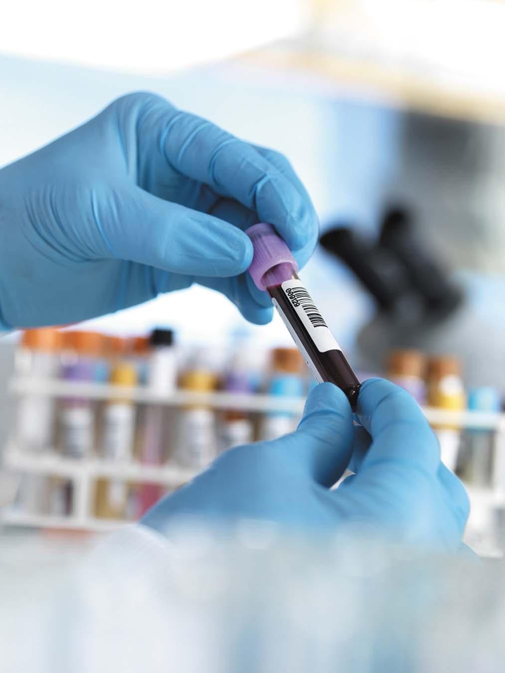 A Lab Access scientist handling a labelled blood sample tube